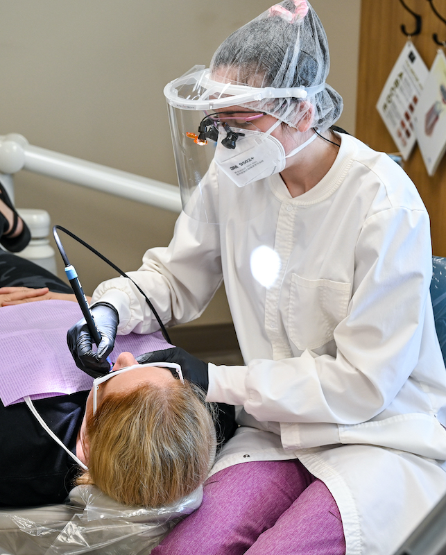 student working with patient in dental clinic