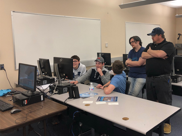 College student and Professor assists with Cyber Camp