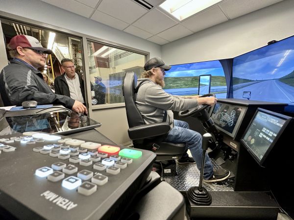 Instructor Jeremy Hitchcock, left, gave people the chance to drive Great Falls College's new simulator for the CDL program at a celebration for 10 graduates and industry partners. 