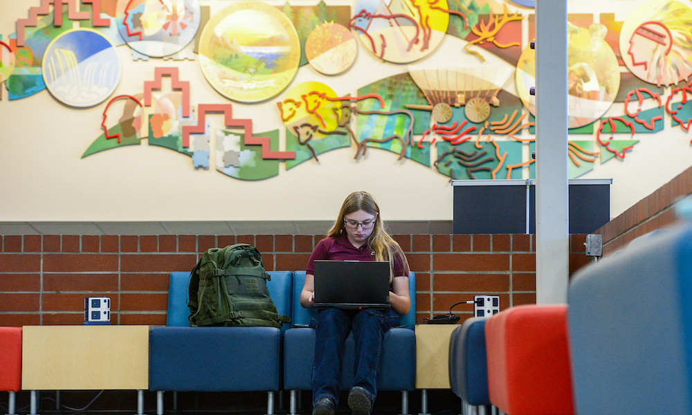 Student studying in seating area near Heritage Hall