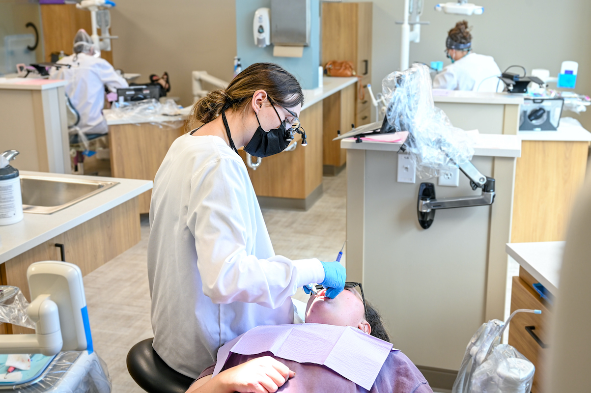student working with patient in dental clinic