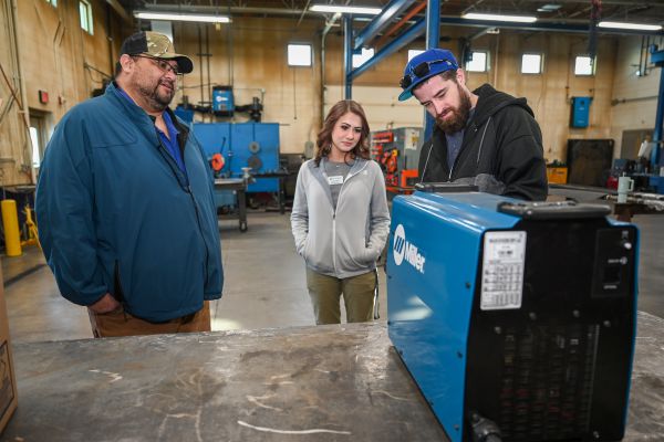 welding professionals discussing a welding machine