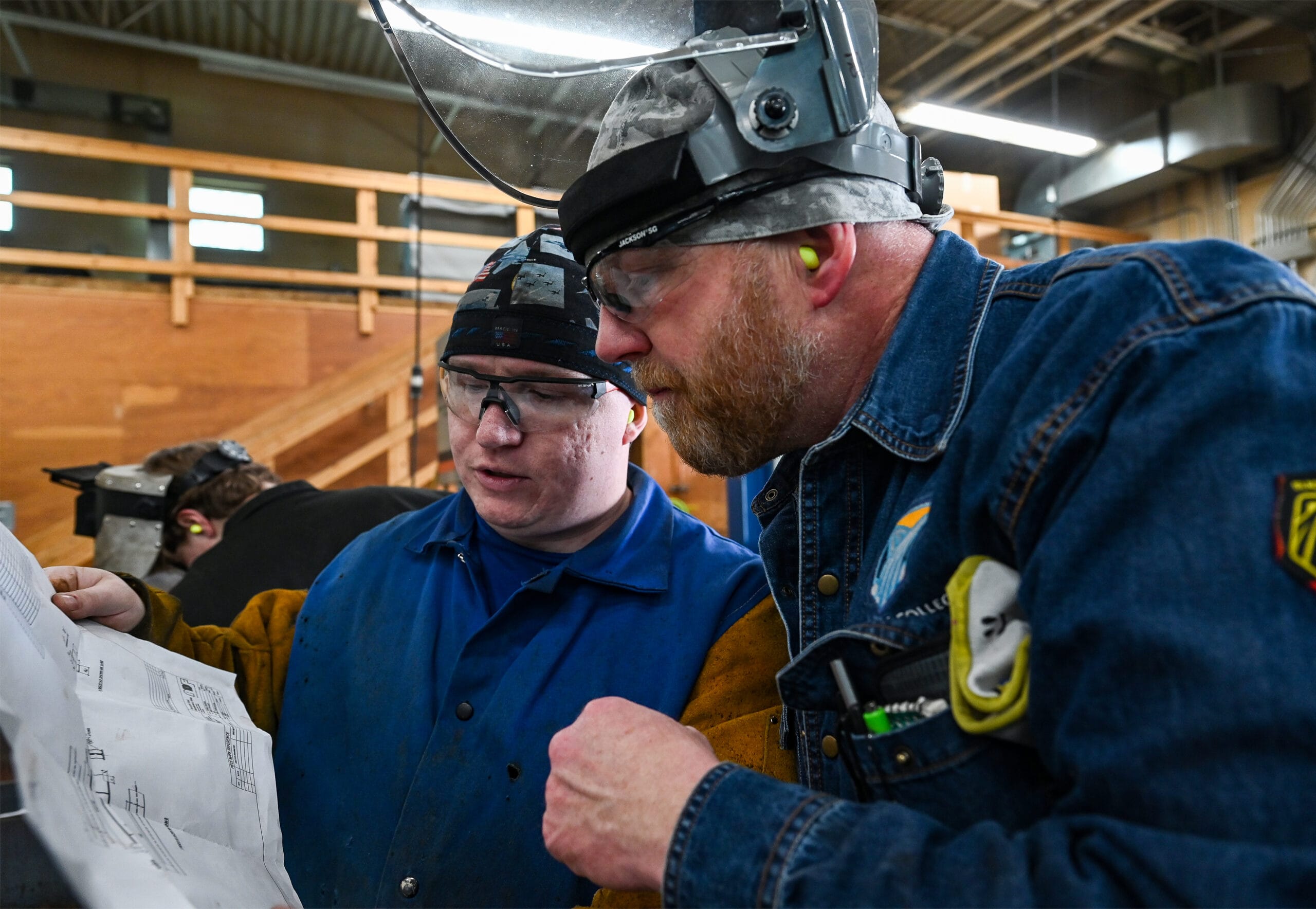Welding instructor Todd Reser inspects a blueprint with first year welding student. Clark Knowles, welding trainer and integration specialist for ADF, works with first year welding students on blueprint reading, and fabrication methods used by ADF. The students worked on fitting parts to beams based on blueprints, March 30, 2023.