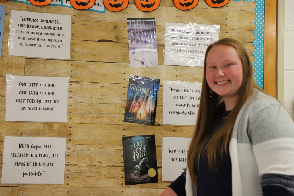 Education student next to a cork board.