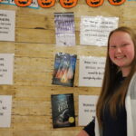 Education student next to a cork board.