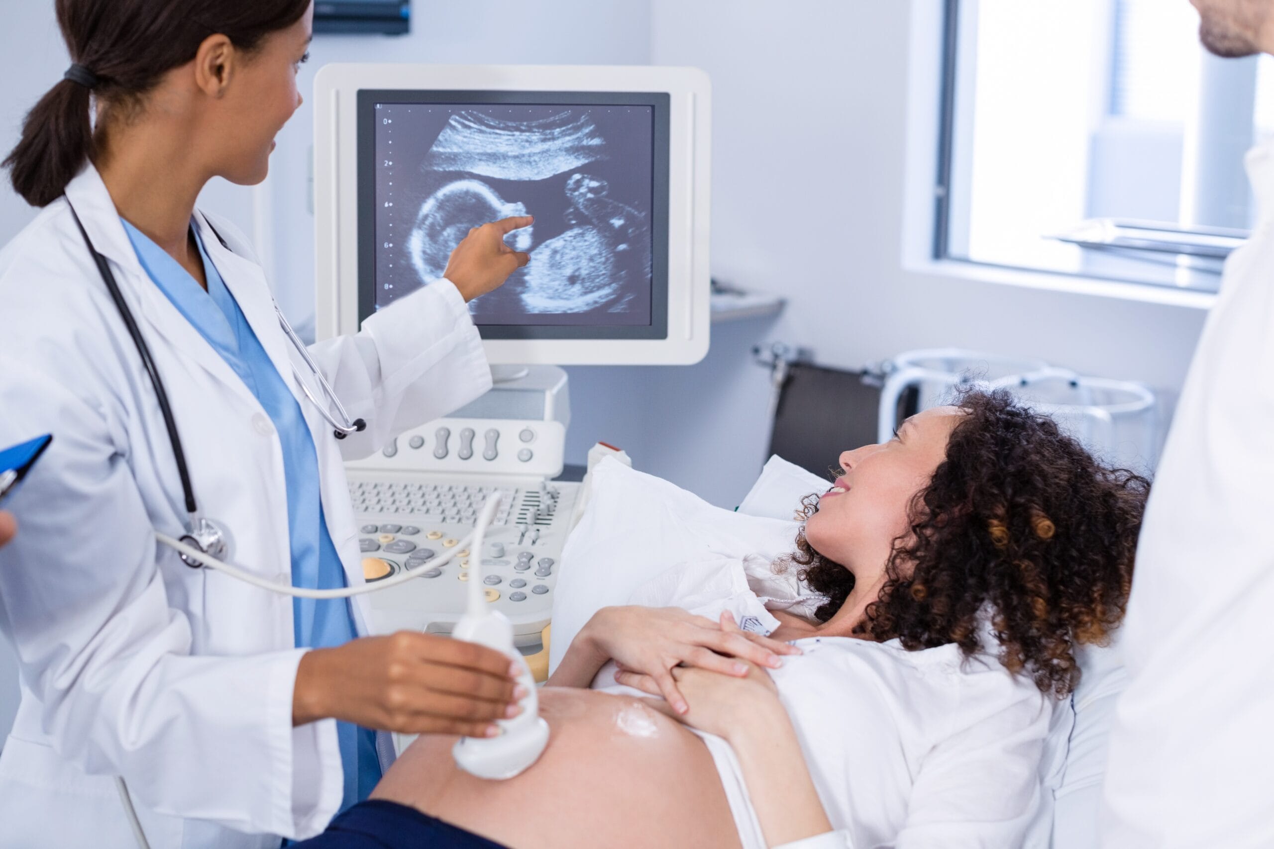 A medical professional performing an ultrasound on a pregnant woman.