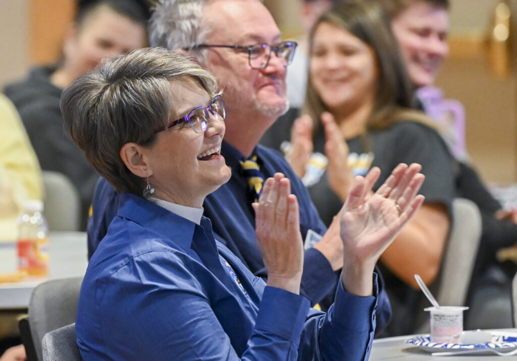 Dr. Stephanie Erdmann smiling and clapping during convocation event.