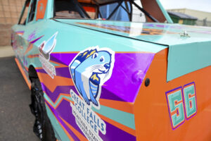 A stock car with the Great Falls College logo on it. 