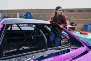 Great Falls College student and stock car driver climbing into her stock car.
